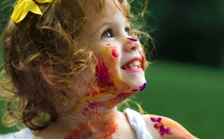 Bambina sorridente con il viso dipinto di colori - Trucca Bimbi Romagna Events